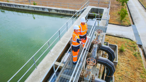 Two water engineers in high visibility gear inspecting a water treatment facility in Australia. Representing the growing demand for water filtration services driven by PFAS concerns in 2026