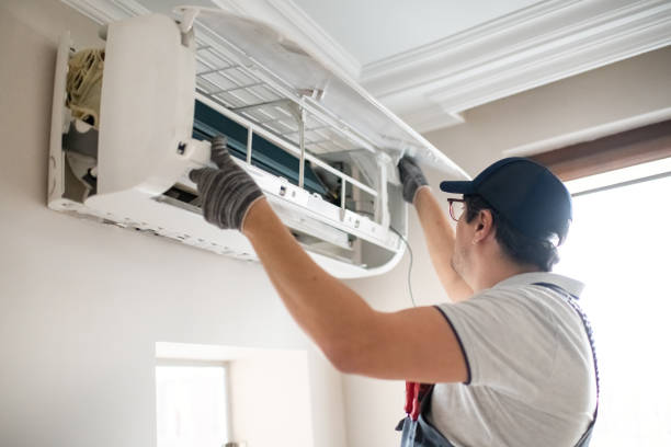 Air conditioning installer servicing a split system unit mounted on an interior wall
